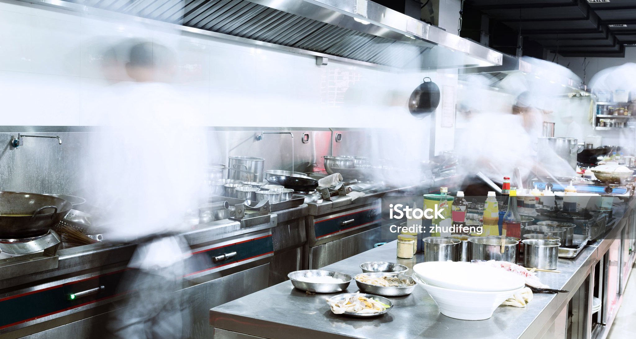 Köche arbeiten im Küchendampf einer Großküche